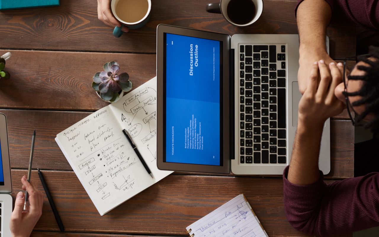 Laptop and notebooks on a desk during a working session on timesheet data
